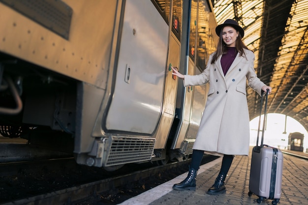 女性が電車のドアのボタンを押して入ります。