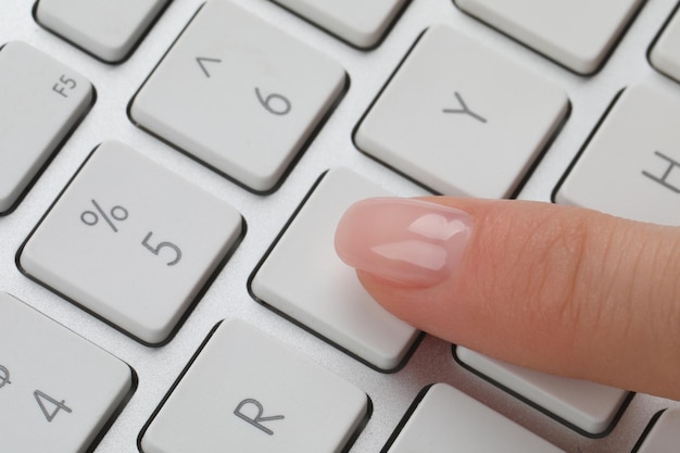 Foto donna che preme il pulsante sul primo piano della tastiera del computer