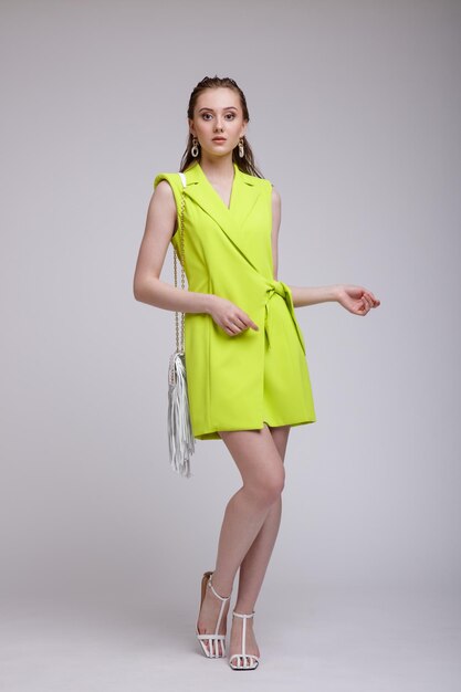 Woman in a pretty acid yellow dress handbag studio shot portrait