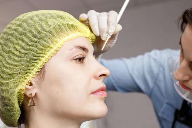 Donna sulla procedura di laminazione e colorazione delle sopracciglia dall'estetista nel salone