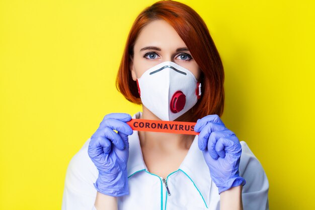 Woman in protective gloves holding inscription coronavirus.