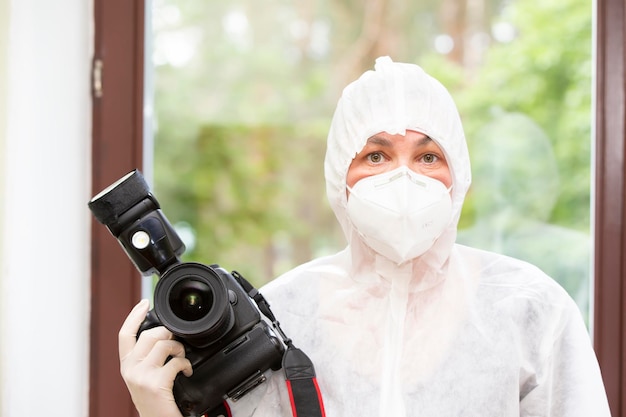 Woman in protective medical clothing with a camera