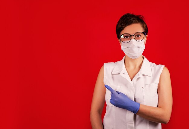 A woman in a protective suit against the COVID-19 virus indicates the direction.