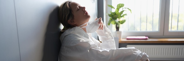 A woman in a protective suit is breathing without a mask