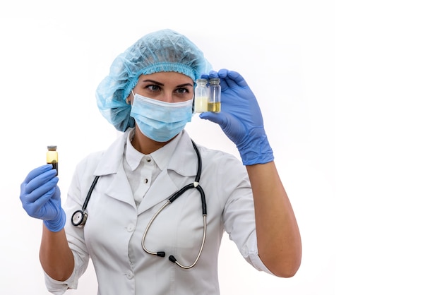 Woman in protective uniform holding different ampoules isolated on white