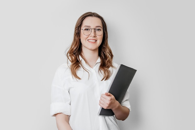 Woman psychologist in a white shirt with glasses on a white background in the studio