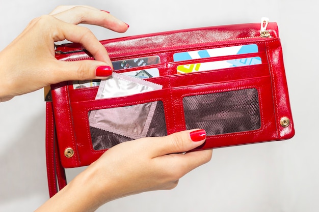 A woman pulls a condom out of her purse