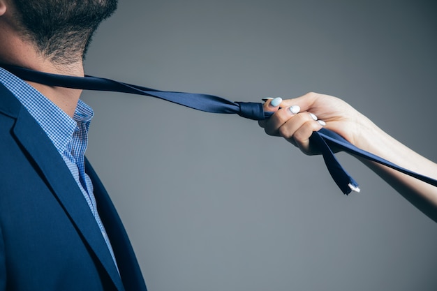 A woman pulls a man's tie