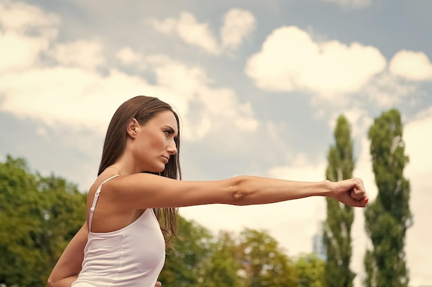 Woman punching at workout sunny outdoor