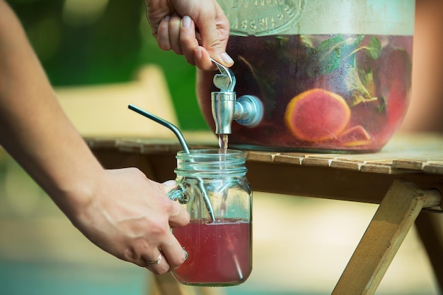 Woman puring lemonade in her masson jar