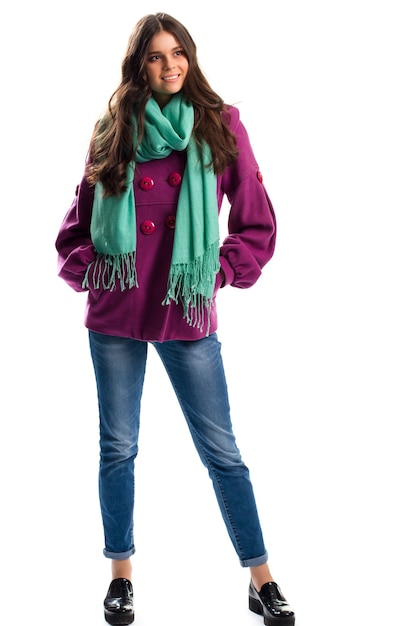 보라색 코트 웃 고 있는 여자. 청바지와 검은 광택 신발. 화려한 스카프로 봄 의상. 고품질 양털 의류.