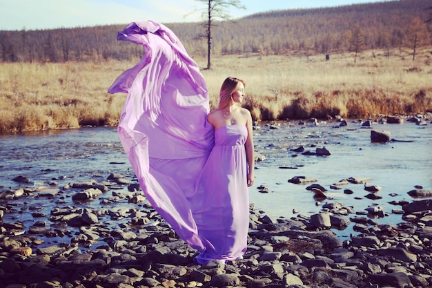 Photo woman in purple dress standing on rocks