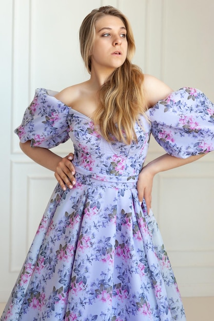 Photo a woman in a purple floral dress with a white background.