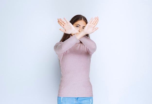 woman in purple shirt rejecting something with hand gests.