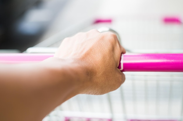 woman push supermarket trolley close up