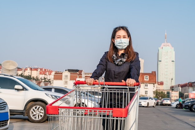 Woman pushing shopping cart in the parking lot