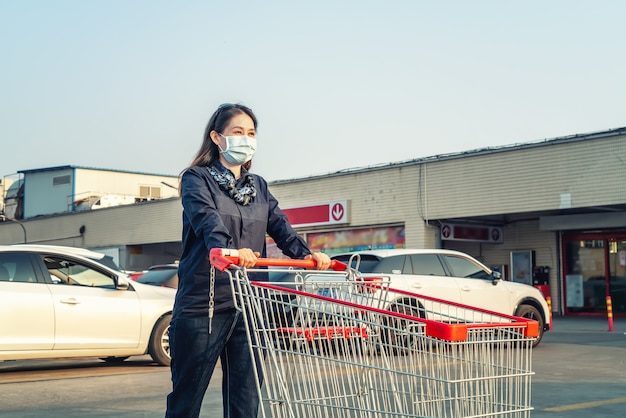 Woman pushing shopping cart in the parking lot