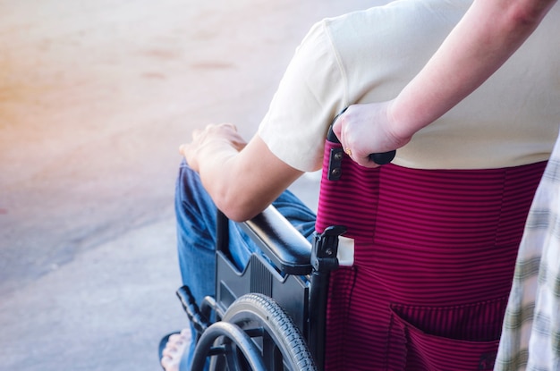 woman pushing wheelchair with men patient