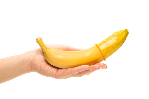 Woman put on a condom on a banana Isolated on a white background