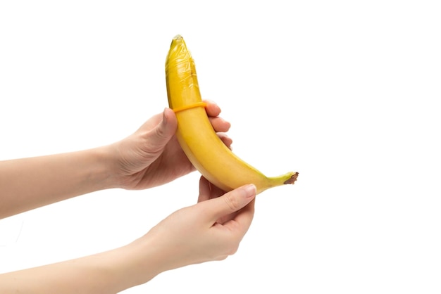 Woman put on a condom on a banana Isolated on white background