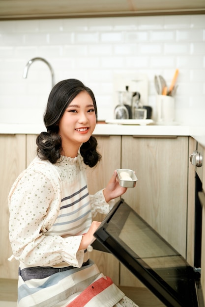 Woman put cookies in stove