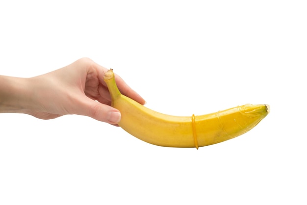 女性は白い背景で隔離バナナにコンドームを置く