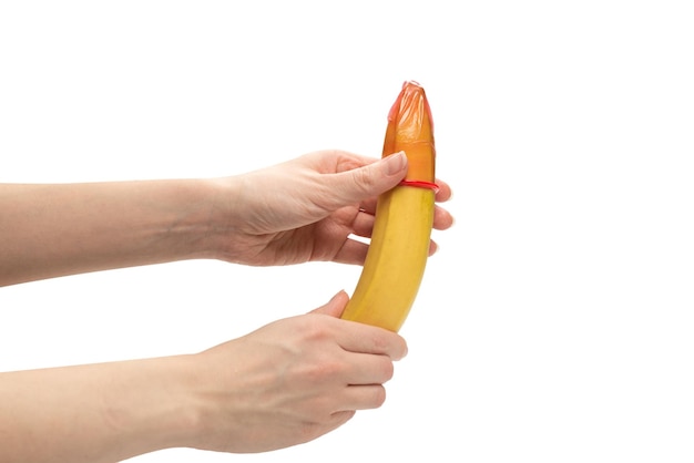 Женщина надела презерватив на банан, изолированный на белом фоне