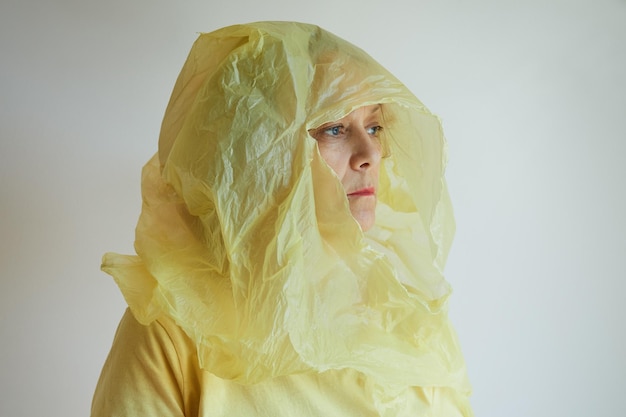 Foto la donna si è messa in testa un sacchetto di plastica strappato giallo, puoi vedere la sua faccia attraverso il buco