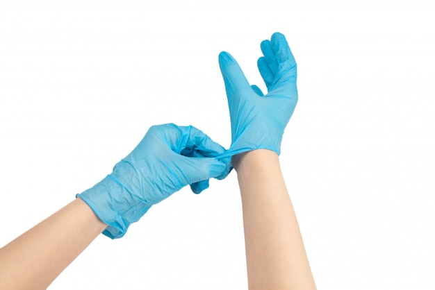 Woman puts on blue rubber gloves.