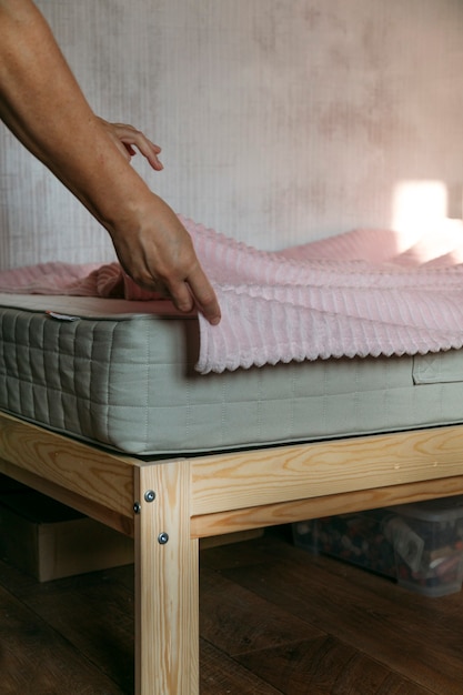 Photo a woman puts a mattress on the bed or postpones the cleaning process