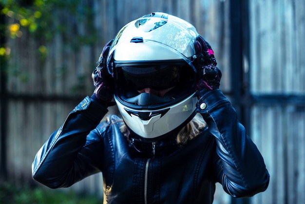 La donna indossa il casco da motociclista e allaccia la chiusura