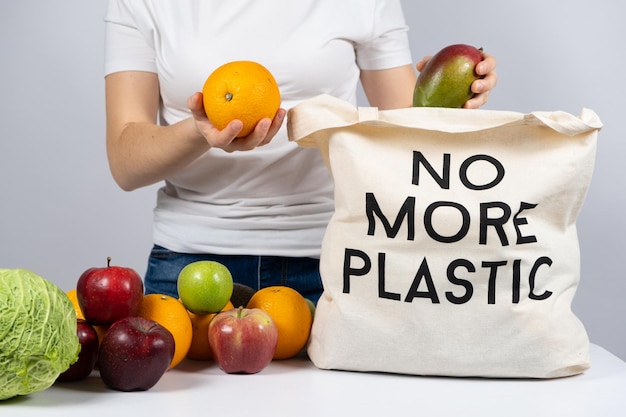 Photo a woman puts products in a fabric eco bag with no more plastic