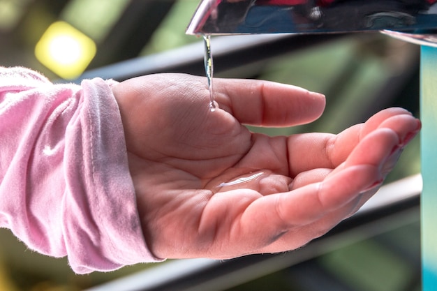 Woman putting alcohol gel on her hand in Rio de Janeiro Brazil.