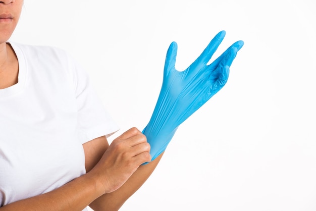 Женщина надевает на руку резиновую перчатку