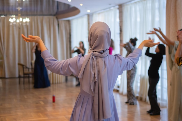 Woman putting hands up and dancing excited young female celebrating a victory muslim woman in tradit...