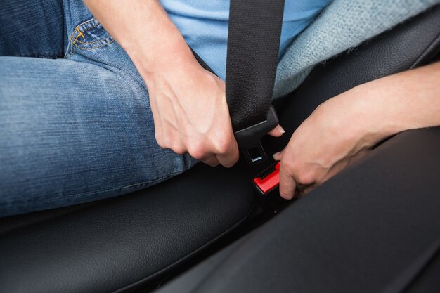 Woman putting on her seat belt 