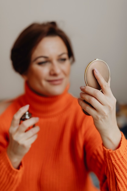 Woman putting on perfume