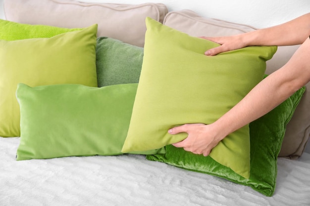 Woman putting pillow on bed closeup