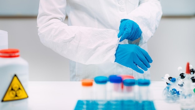 Woman putting protective splash face shield on laboratory safety equipment