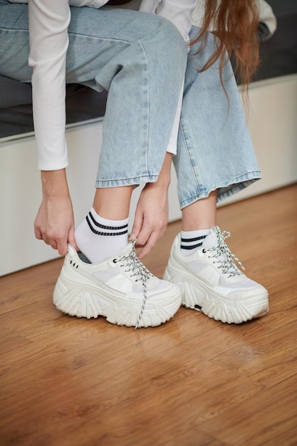 Woman Putting on Sneakers