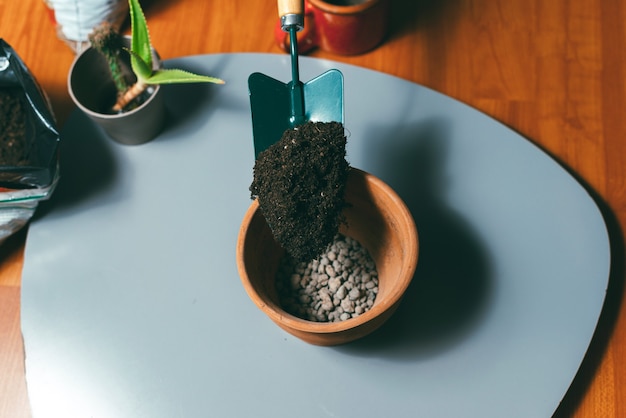 Woman putting some ground in a pot with pebbles