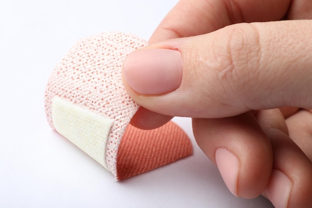 Photo woman putting sticking plaster on white background closeup first aid item