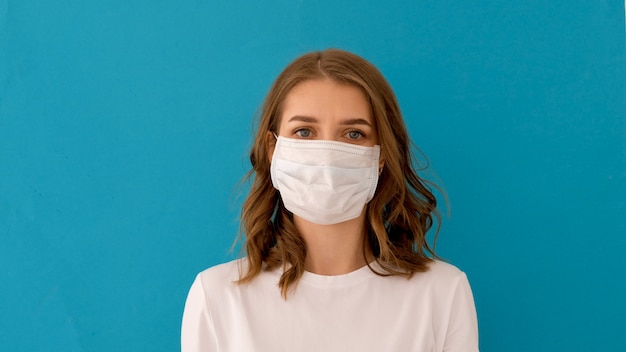Женщина надевает хирургическую маску для профилактики вируса короны