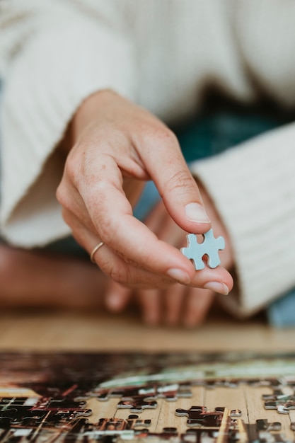 Foto donna che mette insieme un puzzle durante l'autoquarantena