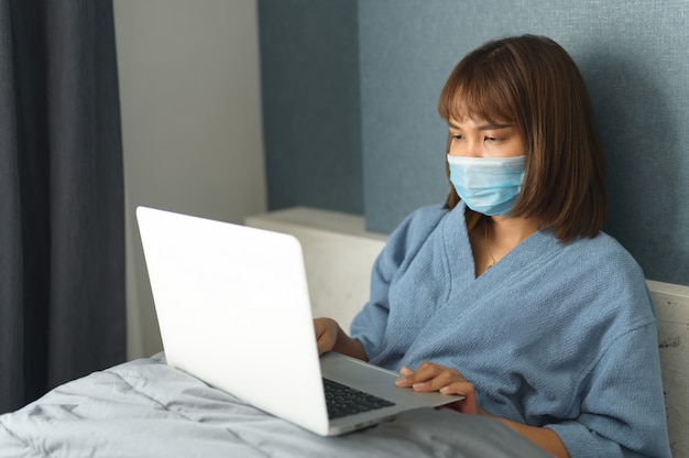 Photo woman in quarantine for coronavirus wearing protective mask and smart working