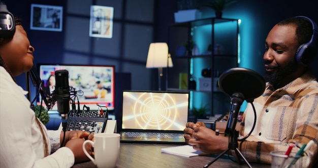 Woman radio show presenter having live conversation with man recording discussion for audience