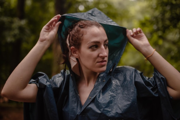 Woman in raincoat on an autumn day adjusting her hood