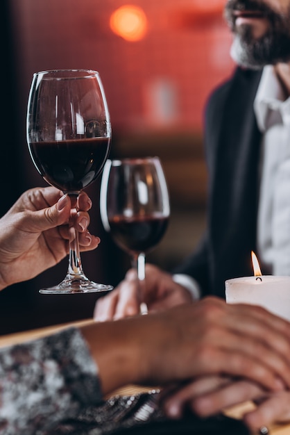 Woman raises a glass and holds the beloved man by the hand