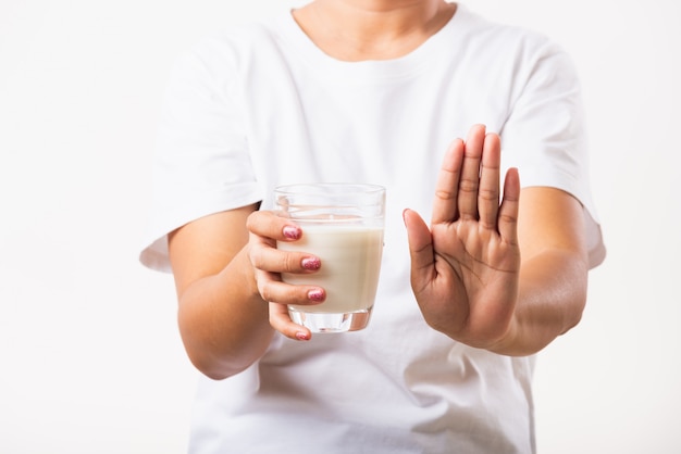 Woman raises a hand to stop sign use hand holding glass milk she is bad stomach ache has bad lactose