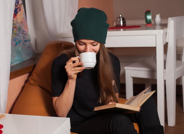 Woman reading book and drinking tea in cafe